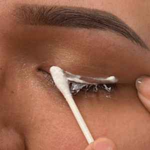 Woman applying aftercare to new eyeliner PMU using a q-tip
