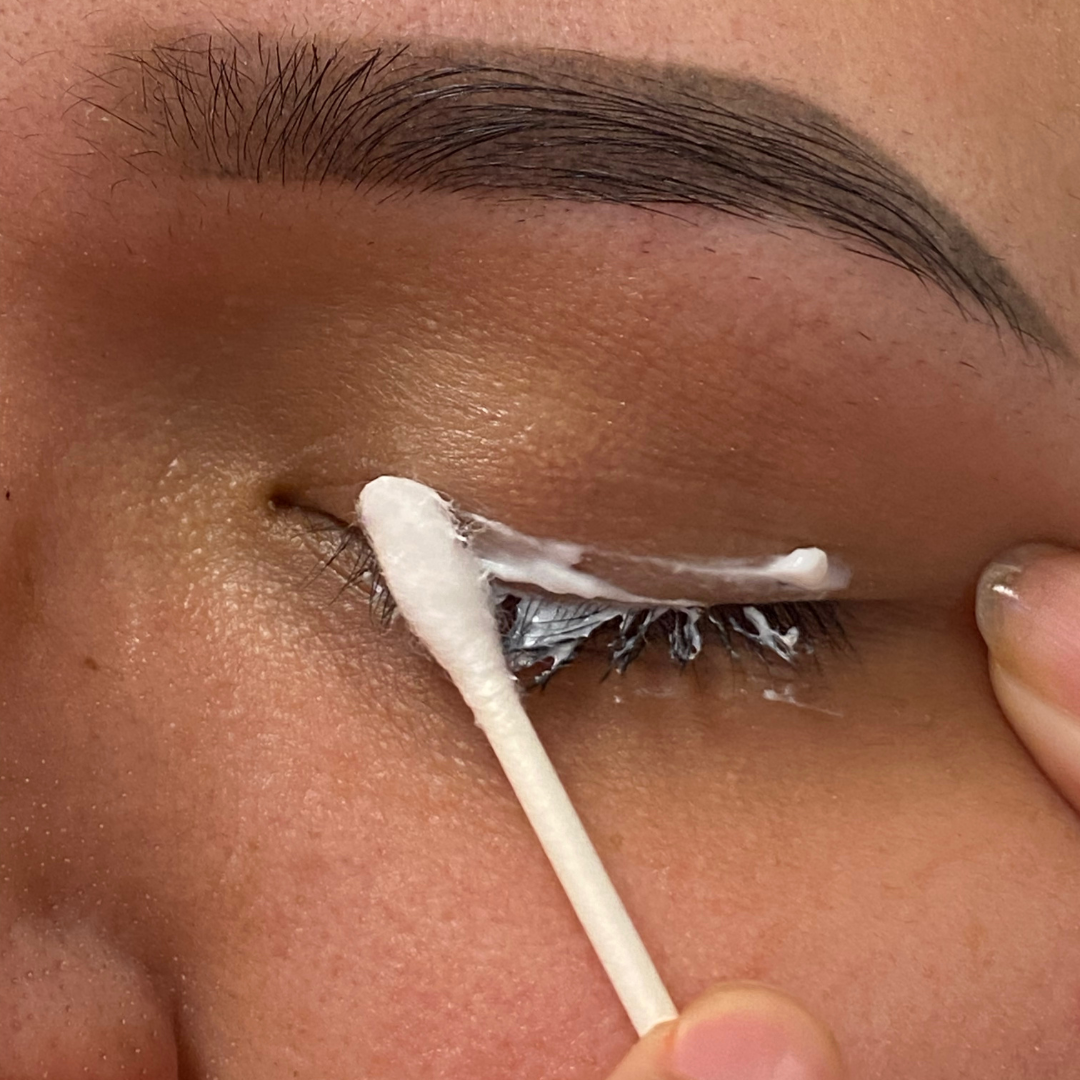 Woman applying aftercare to new eyeliner PMU using a q-tip
