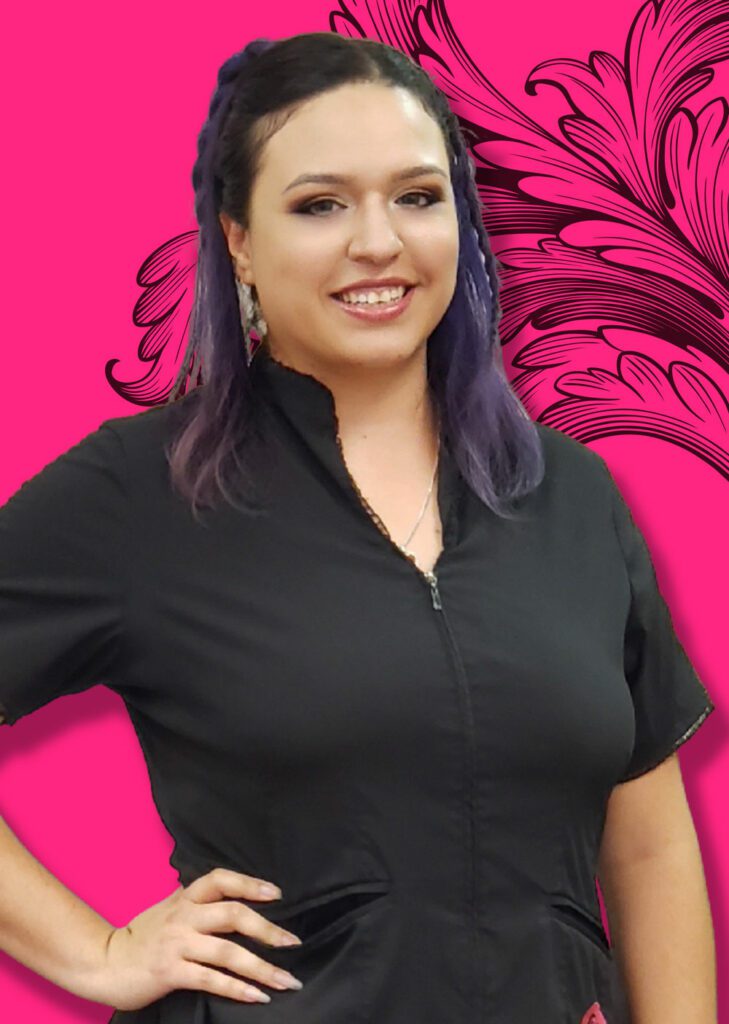 Graphic Designer and Marketer Olivia standing with left hand on hip in front of traditional tattoo background art.